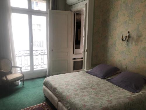 une chambre avec un lit et une grande fenêtre dans l'établissement PLACE VENDOME 1 BR AND 1 BA - up to 4 people - WITH AIR CONDITIONNING, à Paris