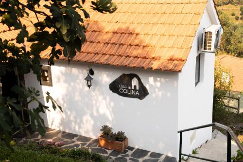 a white house with a sign on the side of it at Casa da Colina in Amarante
