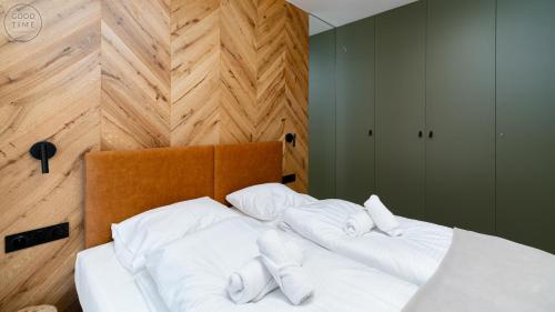 a bed with white sheets and pillows on it at Apartamenty Good Time - Belle View - Centrum in Szklarska Poręba