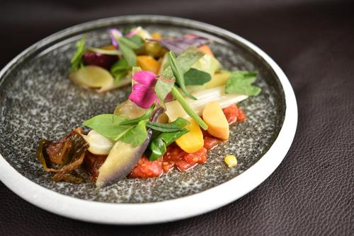 a plate of food with vegetables on a table at Logis Restaurant & Hôtel À la 12 in Delme