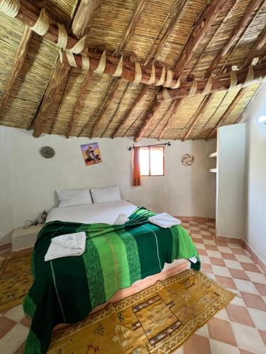 a bedroom with a green and white bed in a room at Les Jardins d Amizmiz 6 piscines in Marrakech