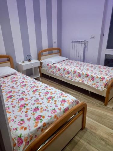 a bedroom with two beds with flowers on them at La tua casa sul Vesuvio e Pompei in Terzigno