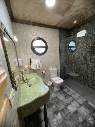a bathroom with a green sink and a toilet at Hotel Restaurante Dama de Baza in Baza