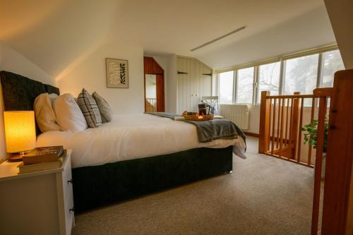 a bedroom with a large bed and a balcony at Mulberry Cottage in Beckford
