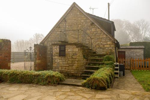 an old stone house with a set of stairs at Mulberry Cottage in Beckford