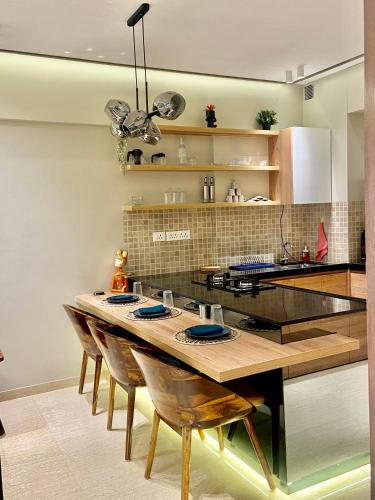 a kitchen with a long wooden table with chairs at The Manor in Pune