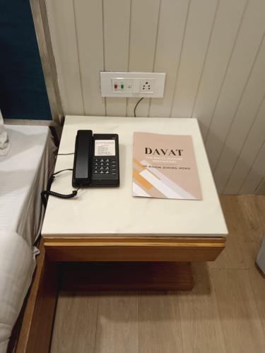 a desk with a phone and a book on it at Hotel Prag Continental in Guwahati