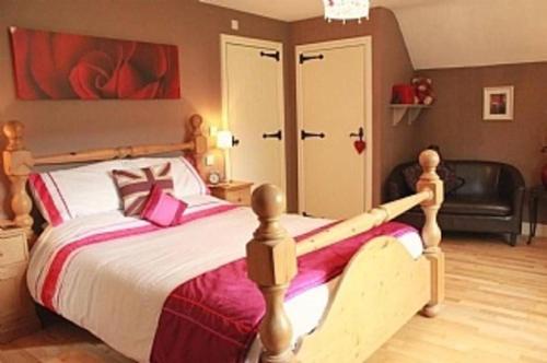 a bedroom with a large bed with a wooden frame at 5-Bed Home - Sleeps 12 Pool Garden & Play Area in Taunton