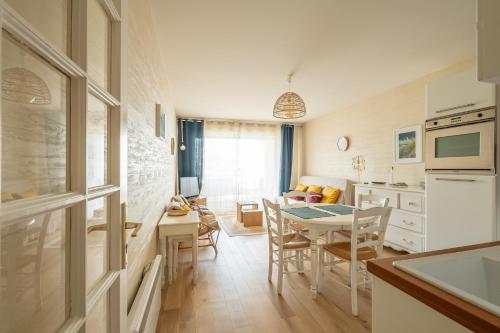 une cuisine et une salle à manger avec une table et des chaises dans l'établissement Agréable appartement et terrasse à 2 pas de la mer, à Wimereux