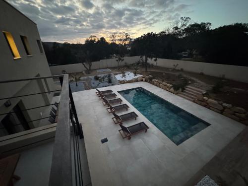 - une vue sur la piscine et ses chaises longues dans l'établissement Villa de standing avec piscine et jacuzzi, à Belgodère