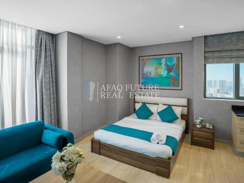 a bedroom with a bed and a blue couch at Vita Tower in Manama