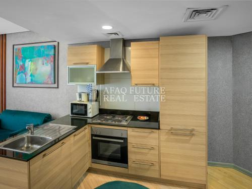 a kitchen with a sink and a stove at Vita Tower in Manama