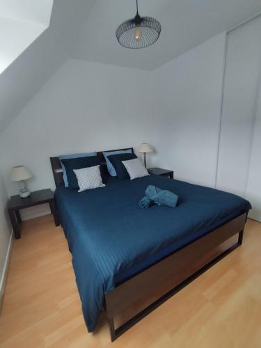 - une chambre dotée d'un lit bleu avec des draps et des oreillers bleus dans l'établissement Maison de la fontaine, à Saint-Méloir-des-Ondes