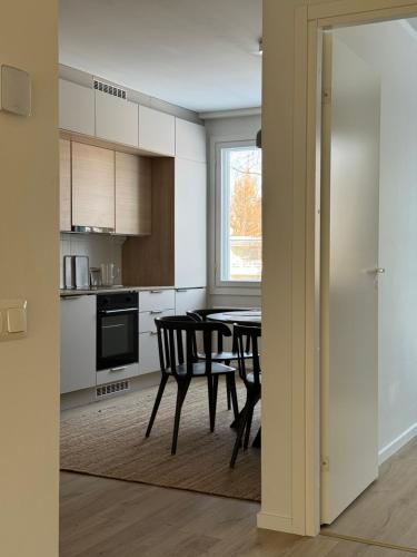 a kitchen and dining room with a table and chairs at Modern and elegant three-room cityhome in Jyväskylä