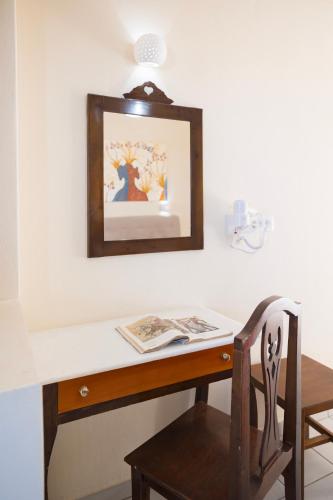a desk with a chair and a picture on the wall at Villa Stella in Fira