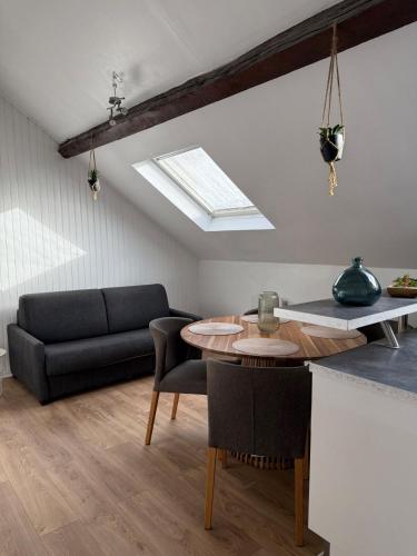 un salon avec une table et un canapé dans l'établissement Charmant T2 près de Disneyland, à Thorigny-sur-Marne