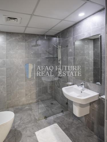 a bathroom with a toilet and a sink and a shower at Vita Tower in Manama
