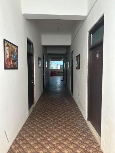 an empty hallway of a building with doors and a tile floor at The kamla palace in Masodha