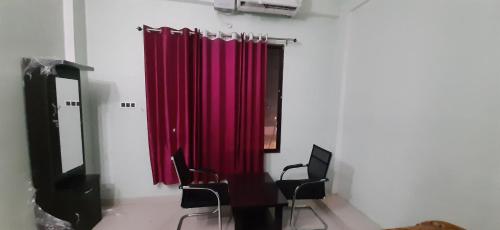 a room with a red curtain and some chairs at The kamla palace in Masodha