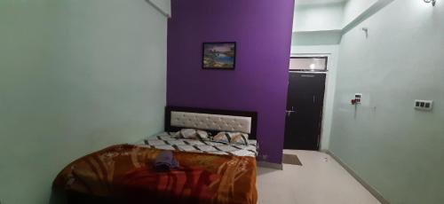 a bedroom with a bed with a purple wall at The kamla palace in Masodha