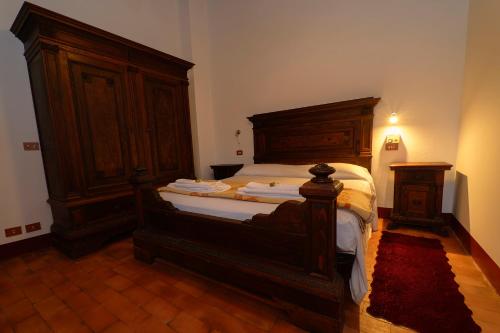 a bedroom with a bed with a wooden headboard at B&b Le Case Rosse in Villa Verucchio
