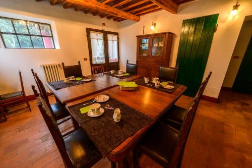 a dining room with a wooden table and chairs at B&b Le Case Rosse in Villa Verucchio