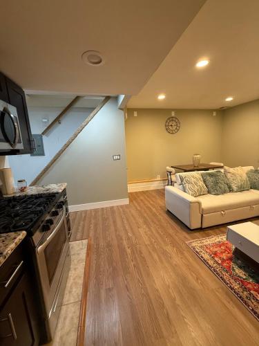 a kitchen and living room with a couch and a stove at Private Guest House-Lake Ronkonkoma in Ronkonkoma