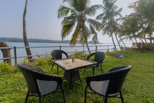 a group of chairs and a table in front of the water at Almeida River View in Hangārkatta