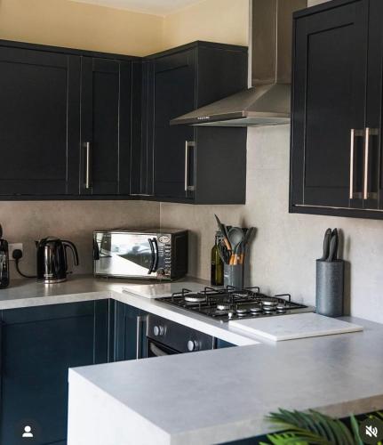a kitchen with black cabinets and a stove top oven at The Taproom in Scarborough