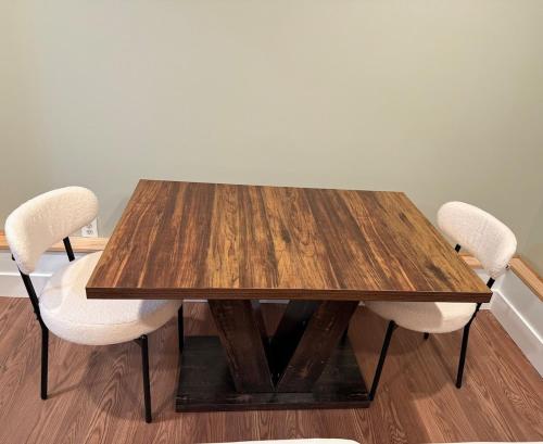 a wooden table with two white chairs around it at Private Guest House-Lake Ronkonkoma in Ronkonkoma