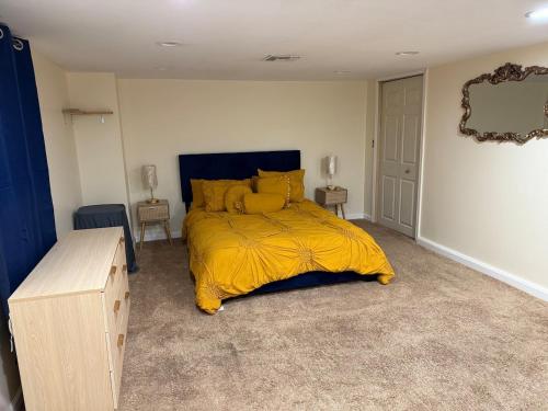 a bedroom with a bed with a yellow blanket at Private Guest House-Lake Ronkonkoma in Ronkonkoma