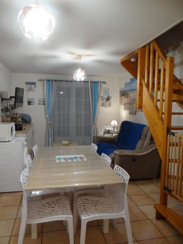 une cuisine et un salon avec une table et des chaises dans l'établissement Villa Sérena la forêt et la plage à quelques minutes!, à Camiers