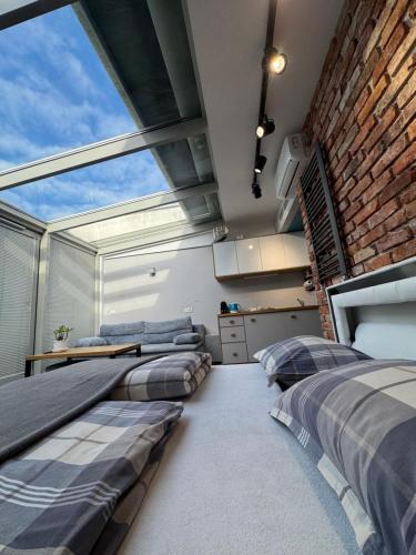 Dos camas en una habitación con una gran ventana. en TOP VIEW SKY & SEA- Maloves Władysławowo - Prywatny apartament na wynajem -widok na morze ,taras ,aneks, en Władysławowo
