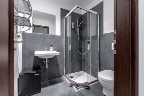 a bathroom with a shower and a toilet and a sink at VV hotel & apartments in Brno