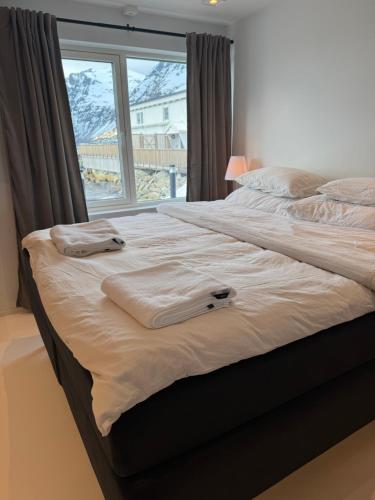 a bedroom with a large bed with towels on it at House of Ellie in Ersfjordbotn