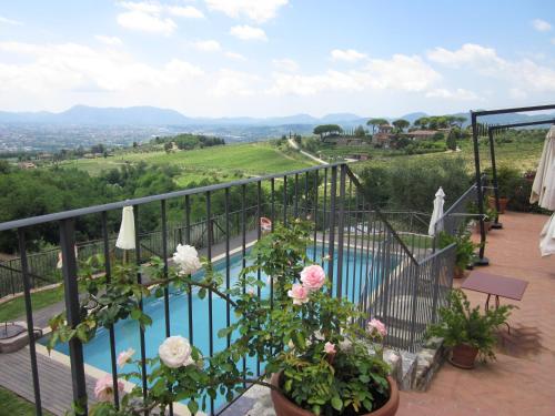 a balcony with a view of a pool and flowers at Tenuta San Pietro Luxury Hotel in Lucca