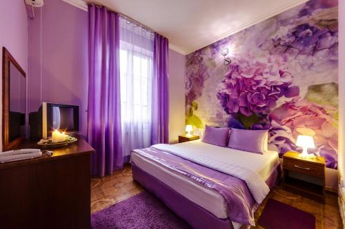 a purple bedroom with a bed and a flower mural at Marton Lion Krasnodar in Krasnodar