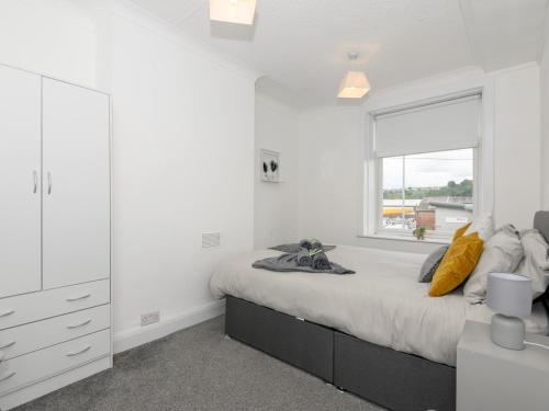 a white bedroom with a large bed and a window at Pass the Keys Brighouse Central - Ideal For Workers in Brighouse