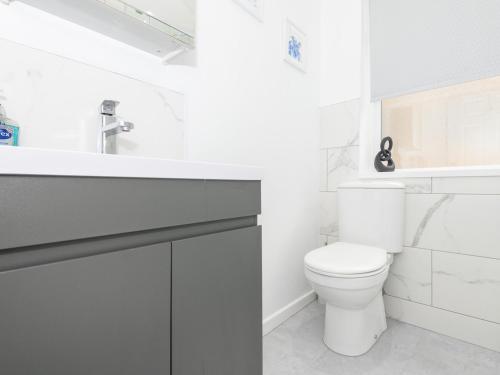 a white bathroom with a toilet and a sink at Pass the Keys Brighouse Central - Ideal For Workers in Brighouse