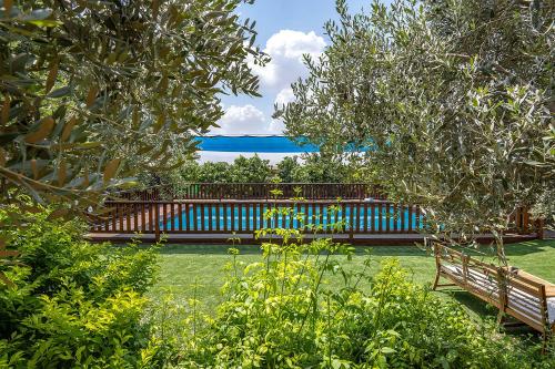 a blue bench sitting in a yard with trees at בקתות רם-מתחם בקתות מהמם עם בריכה פרטית ונוף מושלם in Sede Terumot