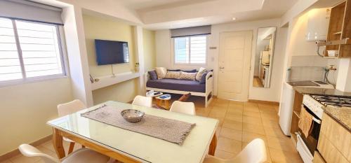eine Küche und ein Esszimmer mit einem Tisch und einer Couch in der Unterkunft Brescia departamentos in San Isidro