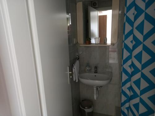 a small bathroom with a sink and a mirror at Rooms Radic in Dubrovnik