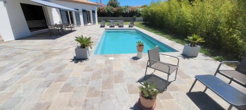 - une piscine dans un patio avec des chaises et des plantes dans l'établissement villa, à Lorgues