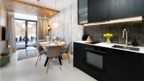 a kitchen with a table and a dining room at Apartamenty Good Time - Belle View - Centrum in Szklarska Poręba