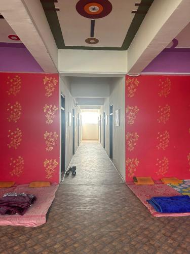 a corridor with red walls and a hallway with beds at The kamla palace in Masodha