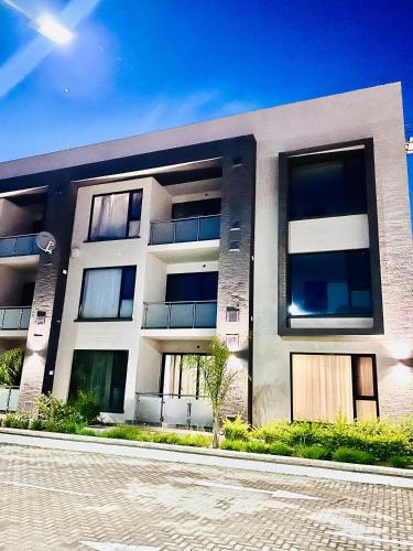 a large white building with windows on a street at Studio 19 Diamond-2bedroom apartment in Gaborone