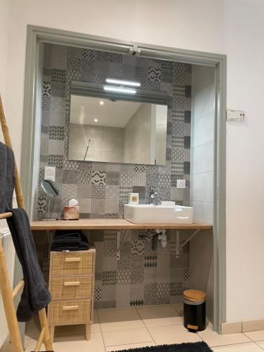 une salle de bain avec un lavabo et un miroir dans l'établissement Maison Côté Halle 