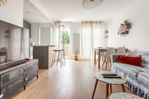 un salon avec un canapé et une table dans l'établissement Bel appartement calme à Bois-Colombes, à Bois-Colombes