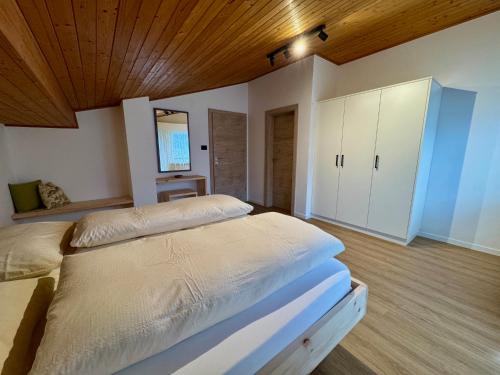 a bedroom with two beds and a wooden ceiling at Klostergut in Castelbello-ciardes