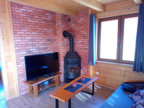 a living room with a brick wall and a stove at Słoneczne Chaty Kasina Wielka in Kasina Wielka